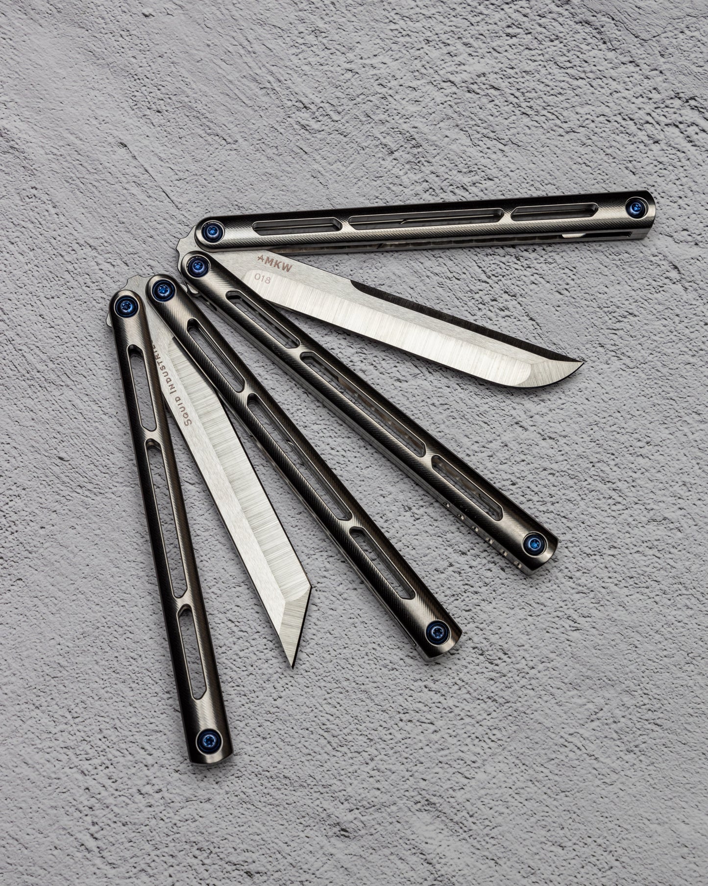 AMKW Tsuami Tanto and Classic Blade Half Open on Gray Surface