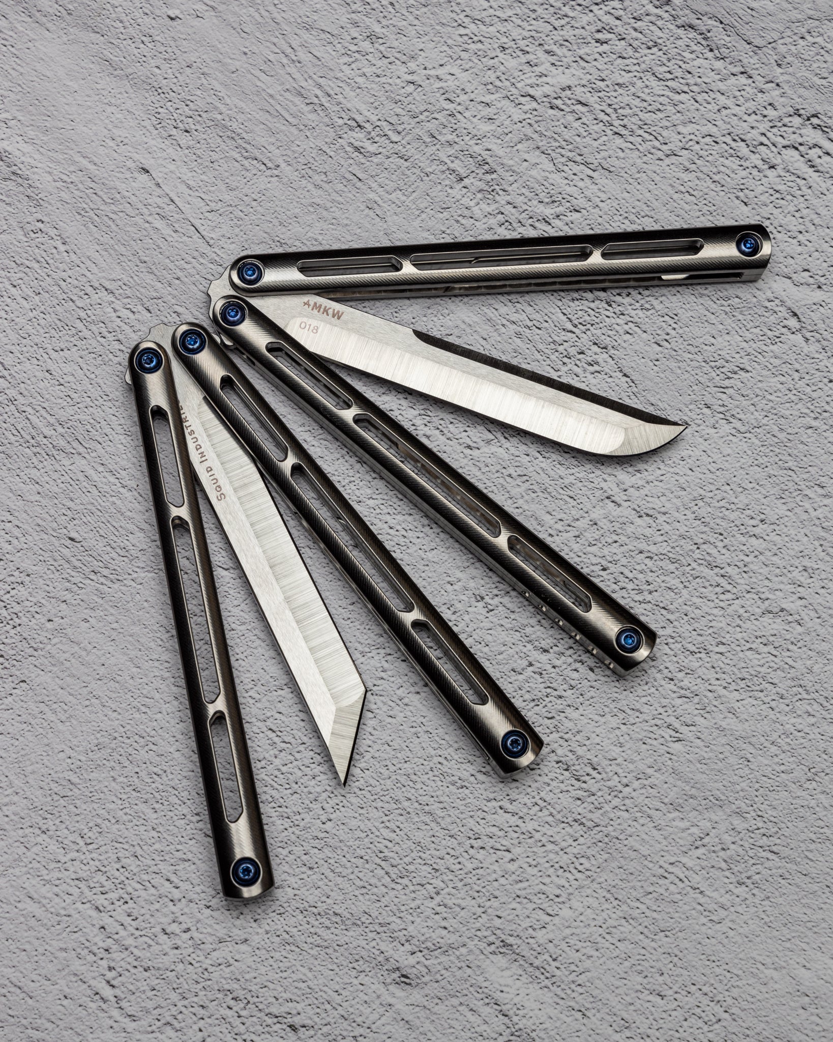 AMKW Tsuami Tanto and Classic Blade Half Open on Gray Surface